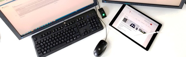Schreibtisch mit Bildschirmen, Tastatur und Mouse
