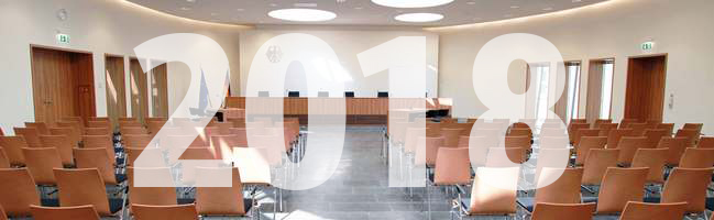 Blick auf die Richterbank im Elisabeth-Selbert-Saal des Bundessozialgerichts, davor ist die Jahreszahl 2018 eingeblendet.