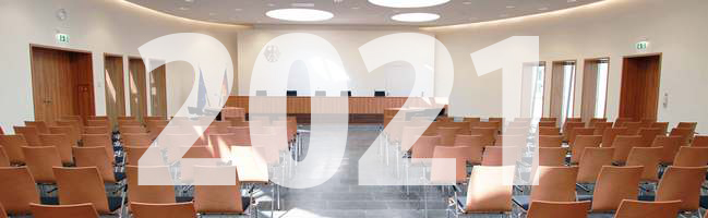 Blick auf die Richterbank im Elisabeth-Selbert-Saal des Bundessozialgerichts, davor ist die Jahreszahl 2021 eingeblendet.