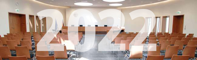 Blick auf die Richterbank im Elisabeth-Selbert-Saal des Bundessozialgerichts, davor ist die Jahreszahl 2022 eingeblendet.